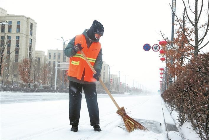 2月26日清晨，邓爱兰在双河市军垦路上清扫路边积雪。 兵团日报常驻记者 雷蕾 摄