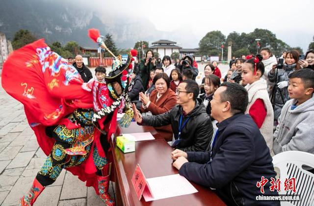 图为村民和游客零距离观看川剧变脸。史开心 摄