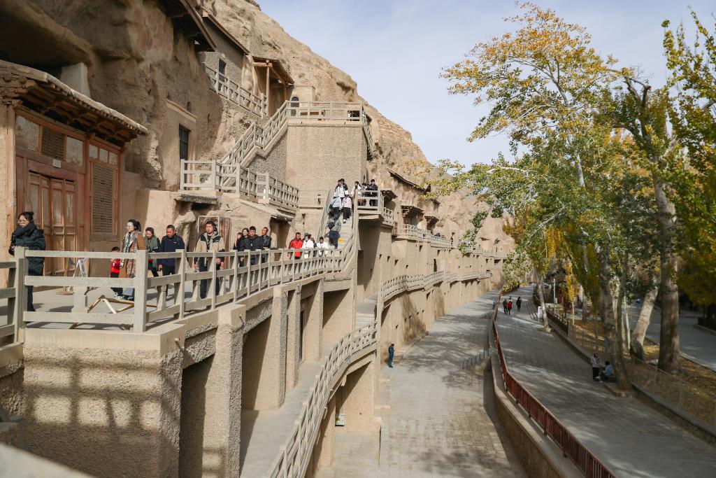 2024年11月14日，初冬时节，游客在莫高窟参观游览。新华社记者郎兵兵摄