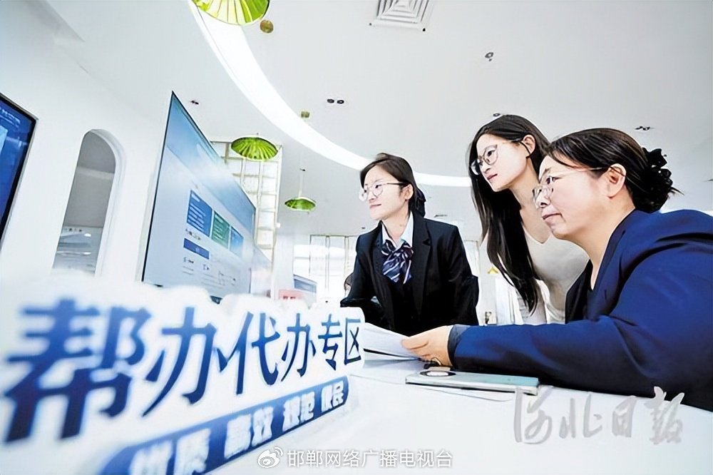 10月29日，邯郸市肥乡区政务服务中心帮办员（左一）帮助企业办事人员填报信息。薛建东摄