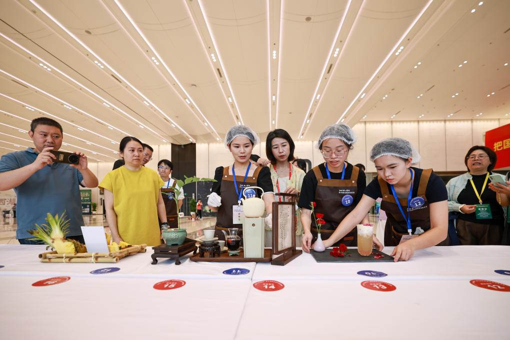 5月21日，观众在茶博会现场的浙江省新式调饮茶技能竞赛上欣赏参赛选手的作品。新华社记者 江汉 摄