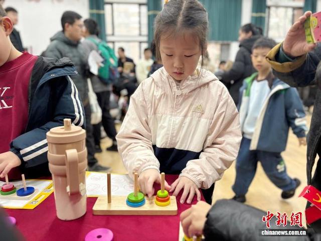 图为参加活动的小朋友体验汉诺塔。高艺芯 摄