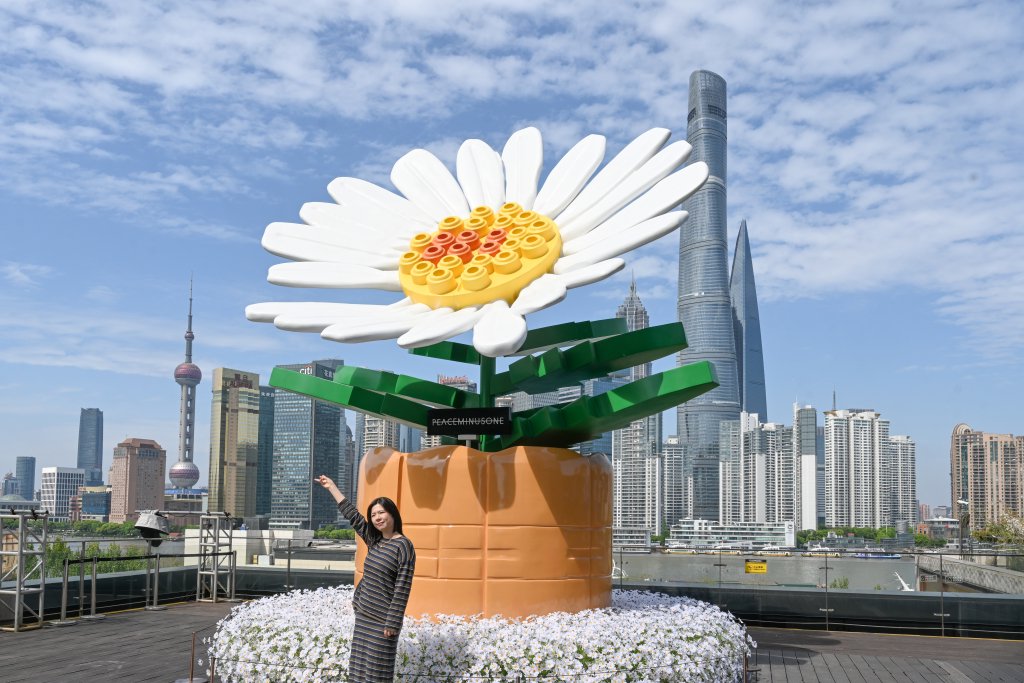 4月18日，上海，BFC南区5层露台，游客和权志龙6米818 BLOOM MEGA积木装置合影。澎湃新闻记者 朱伟辉 图