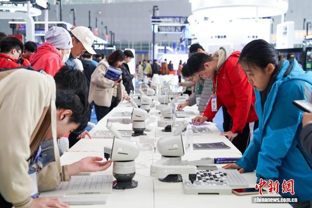 10月24日，黑龙江哈尔滨，观展者与AI下棋机器人博弈。中新社记者 赵宇航 摄