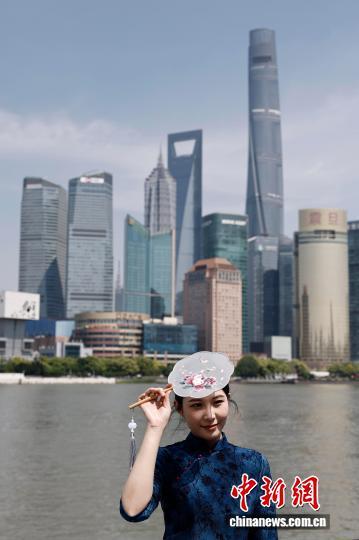 5月1日，游客在上海市黄浦区外滩滨江步道上拍照，享受“五一”假期户外生活。中新社记者 殷立勤 摄