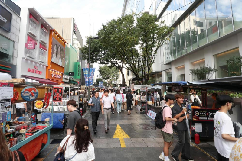 8月6日，游客在韩国首尔明洞商圈游览。新华社记者姚琪琳摄