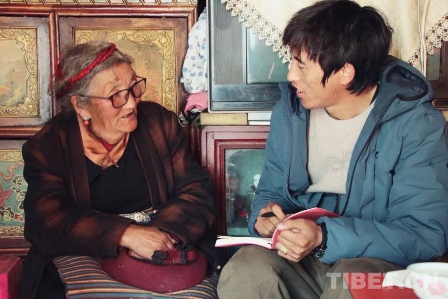 图为达瓦格桑在村民家倾听并记录老人口述历史