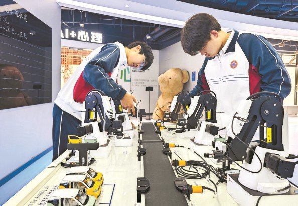 在“AI Tech School”的未来科学中心，学生在体验迷你工业机器人汽车制造流水线 本报记者 陶磊 摄