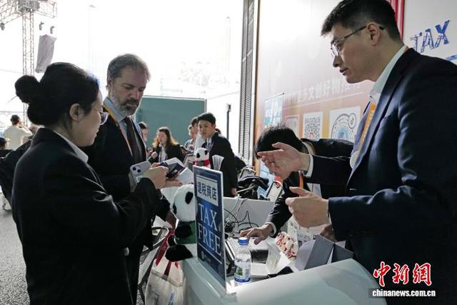 11月9日，在文创馆门口，工作人员协助外籍人员办理离境退税手续。中新社记者 殷立勤 摄