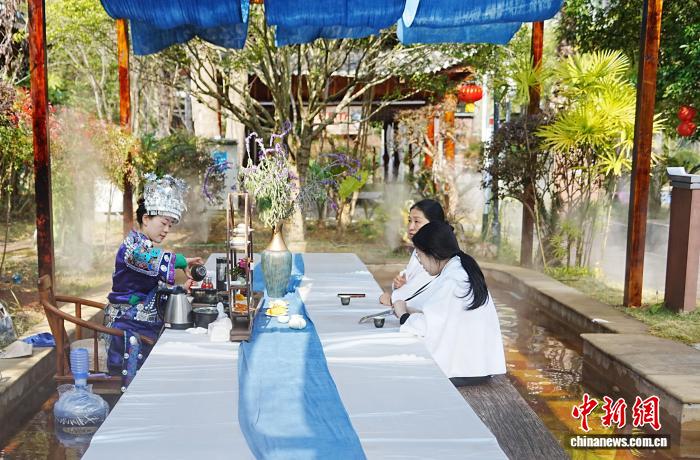 图为游客在剑河仰阿莎温泉小镇一边泡温泉一边喝茶。记者 周燕玲 摄