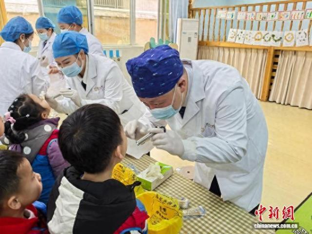 1月8日，台湾青年牙医苏荣邦(右一)与妻子在芷江县的幼儿园开展公益活动。 付敬懿 摄