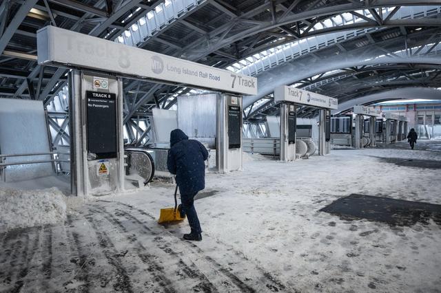 2月23日，美国纽约皇后区，长岛铁路系统因暴风雪关闭，工人在站台上清理积雪。视觉中国 图