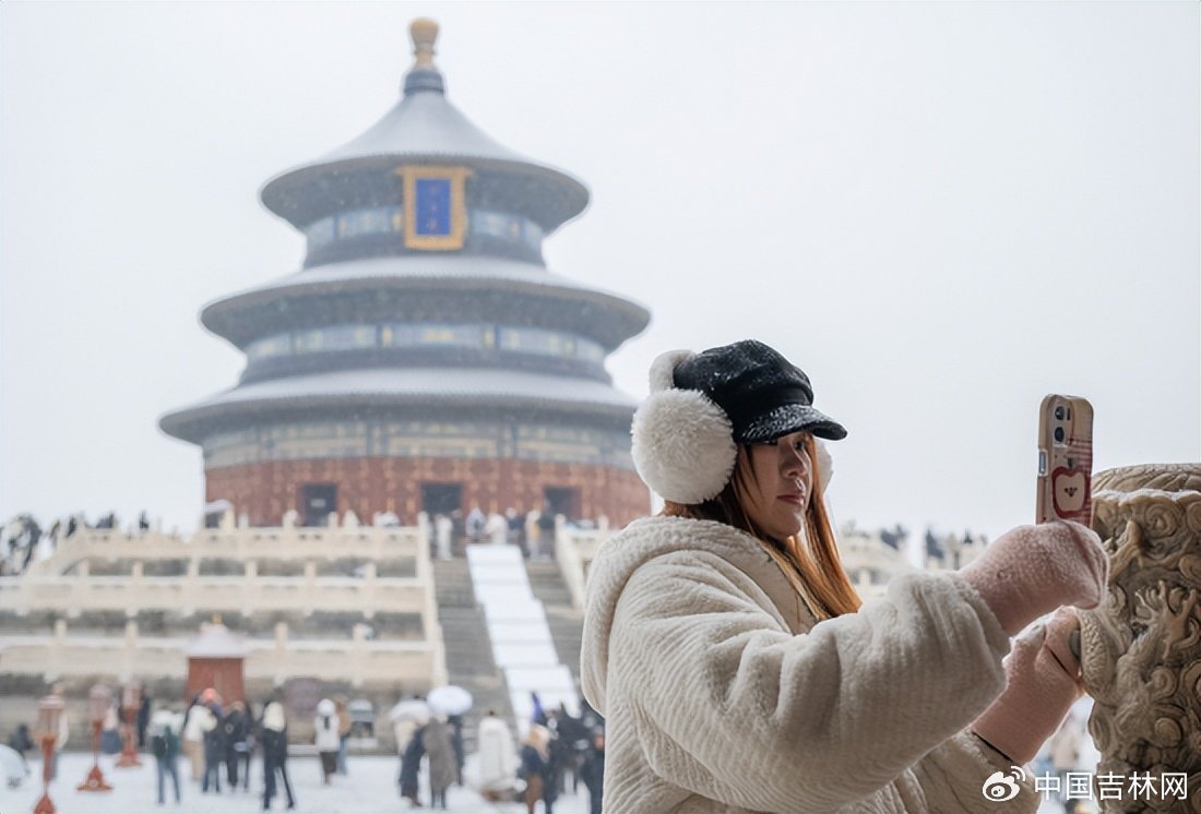 游客在北京天坛公园赏雪拍照 新华社