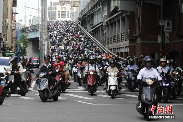 7月13日，台北市台北桥附近，大量民众骑车经过。中新社记者 陈建新 摄