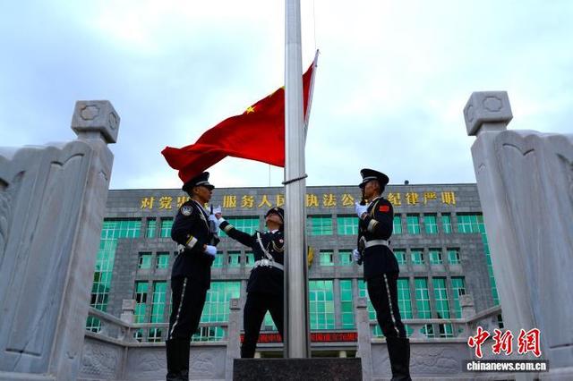 10月1日，戍守在中缅边境云南省德宏州瑞丽市的瑞丽出入境边防检查站举行国庆升旗仪式。图为国旗升起。高运畅治 摄