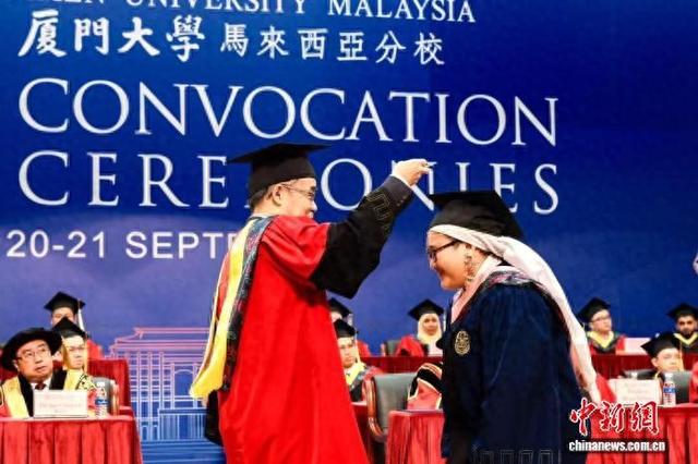 厦门大学校长张宗益(左)为毕业生拨穗。记者 陈悦 摄