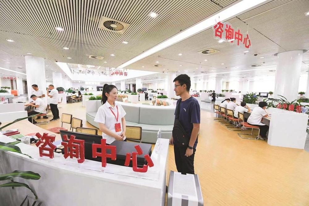 市政务服务中心工作人员为办事群众答疑解惑。 市行政审批局供图