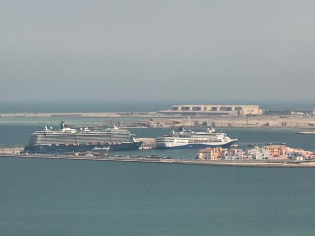 这是3月6日在卡塔尔首都多哈的港口拍摄的滞留的“迈希夫五号”邮轮（左）（手机照片）。新华社记者汪强摄