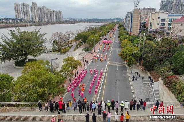 图为巡游队伍从兴国县城的道路上走过，民众在桥上观看。(无人机照片)中新社记者 刘力鑫 摄