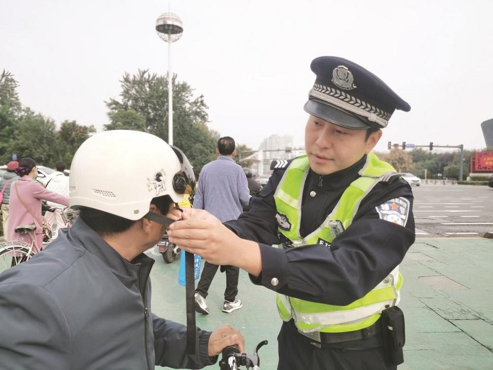 近日，市公安局交巡警支队规范保障大队民警在滏东大街人民路交通岗区开展“头盔安全佩戴”行动。 辛瑞 摄
