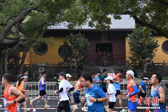 3月22日，参赛者在“南屏晚钟”净慈寺附近进行折返跑。中新社记者 王刚 摄
