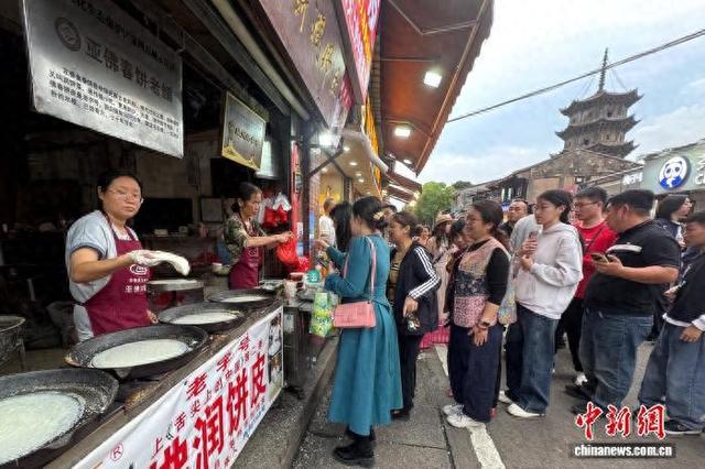 4月4日，福建泉州古城西街的亚佛春饼老铺门前有不少市民游客排队购买润饼皮。柯宁 摄