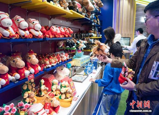 图为来宾在赛场外的纪念品销售处选购礼品。中新网记者 侯宇 摄