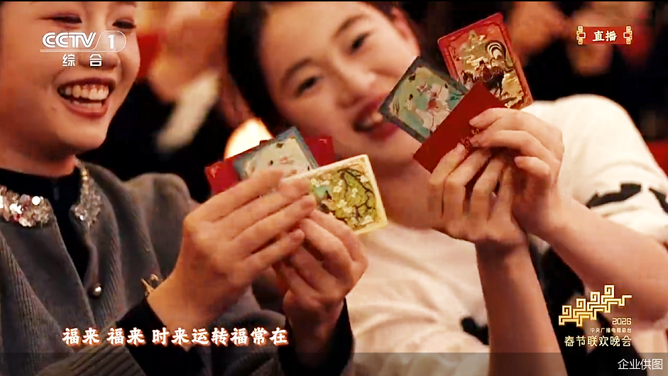 图说：总台马年春晚现场抢到从天而降马年典藏卡的年轻观众。