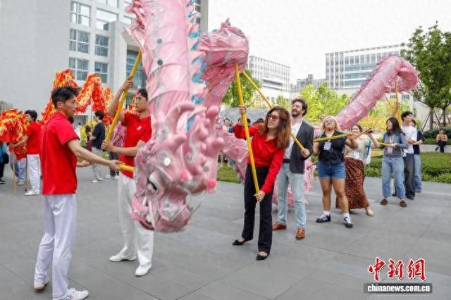 4月9日，美国青年在重庆大学科学中心体验铜梁龙舞。石涛 摄