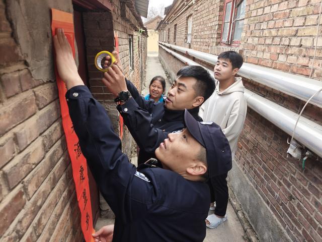 周宪波与同事为社区群众张贴春联。新华社记者王阳 摄