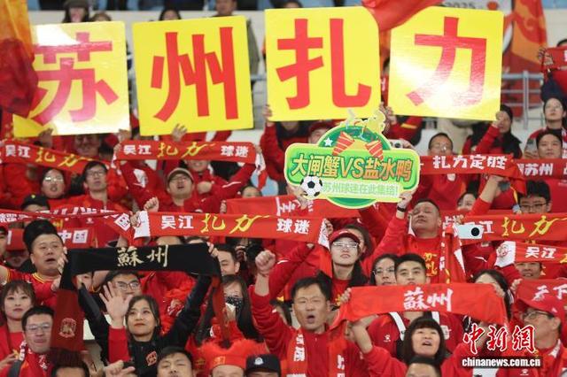 图为苏州队球迷举着“苏州扎力”(扎力，苏州方言，意为：全力以赴)字样的牌子为球队加油助威。中新社记者 泱波 摄