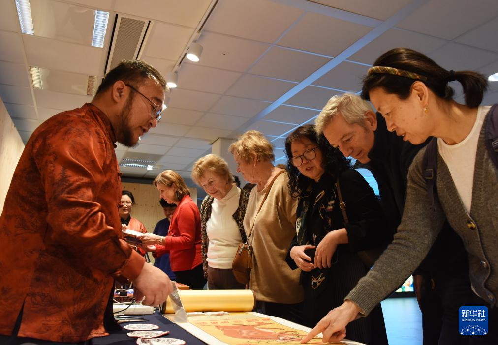 11月26日，在荷兰海牙中国文化中心，蔚县剪纸非遗传承人向嘉宾介绍作品。新华社记者 邵海军 摄