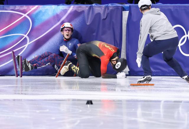 2月14日，中国选手刘少昂（中）在比赛中被摔倒的英国选手特雷西（左）带出赛道。新华社记者 陈益宸 摄