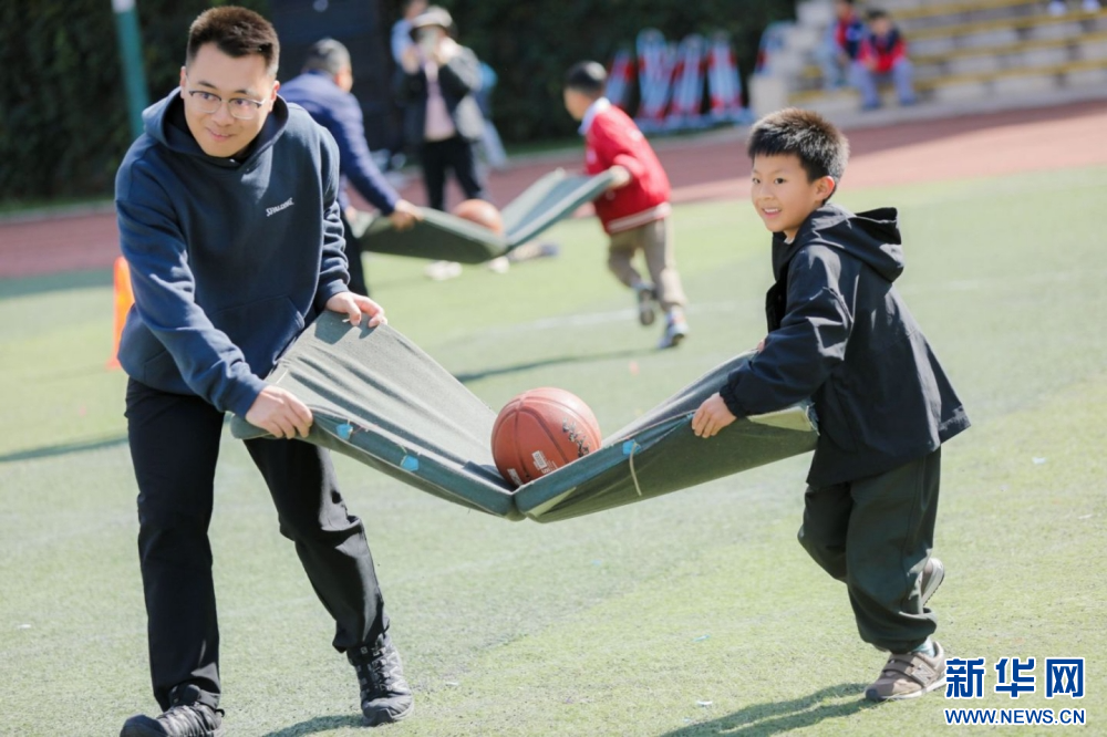 家长和学生参与体育节比赛项目（11月22日摄）。