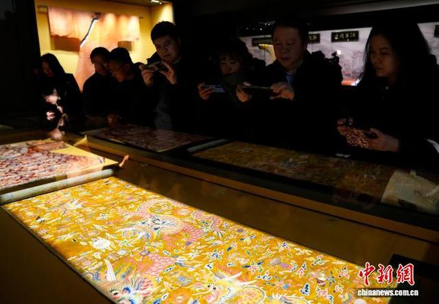 图为观众拍摄展览中的香色地彩云金龙暗八仙纹绒绣织成料。中新社记者 李林 摄