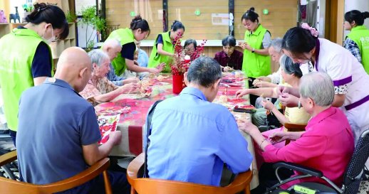 普亲养老长沙桂花坪院,入住老人在护理员的帮助下完成手工制作。   受访者 供图