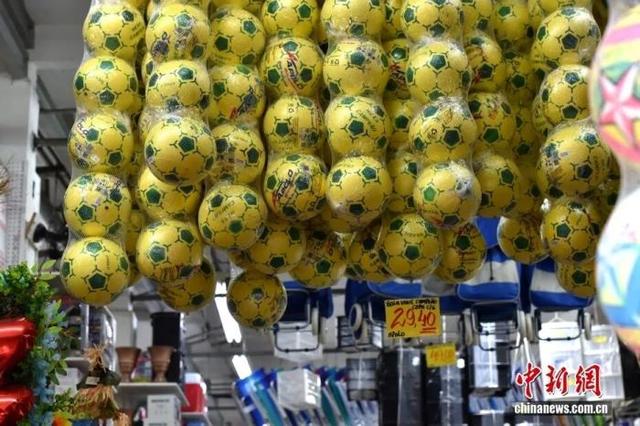 当地时间5月5日，巴西圣保罗25街，店家上架巴西国足特有黄绿色的足球。中新社记者 林春茵 摄