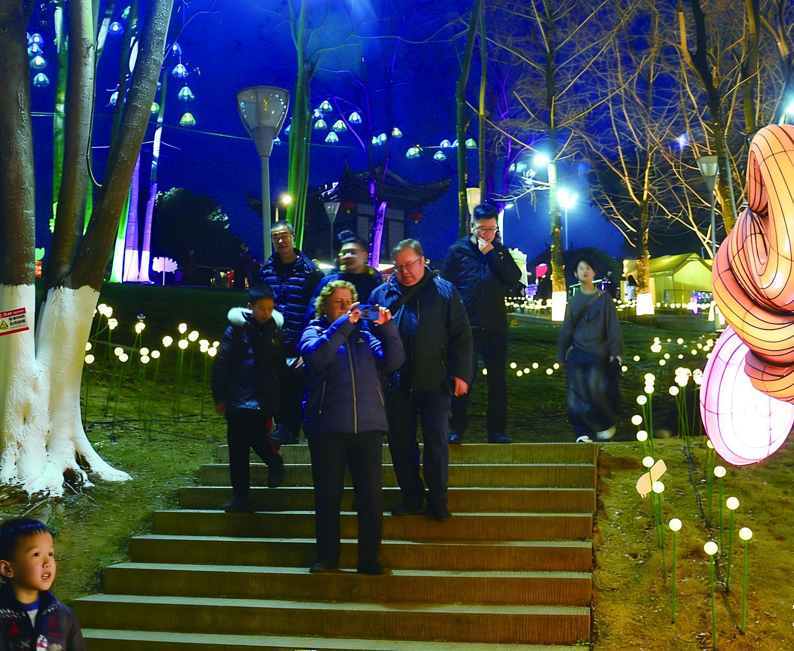 国外游客逛园博园水上灯会,对着灯组拍个不停。