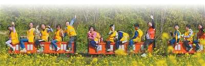 重庆市北碚区歇马街道虎头村，青少年们乘坐小火车感受乡村田园之美，乐享春日假期。秦廷富摄