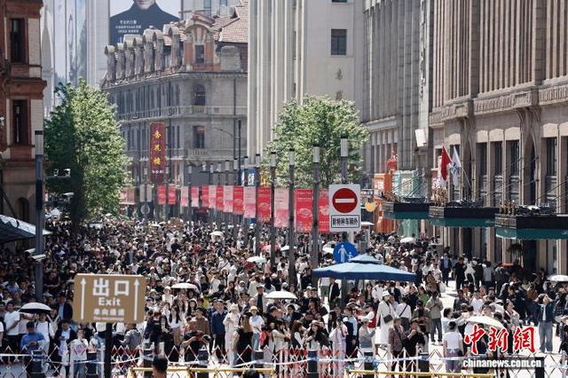 5月1日，游客在上海市黄浦区南京东路步行街上行走，享受“五一”假期户外生活。中新社记者 殷立勤 摄