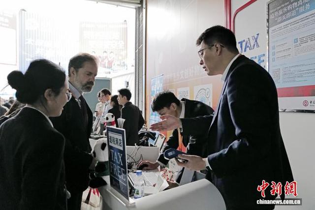 11月9日，在文创馆门口，工作人员协助外籍人员办理离境退税手续。中新社记者 殷立勤 摄