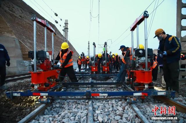 3月14日，铁路职工在兰州境内的包兰铁路水源站进行道岔捣固作业。王光辉 摄