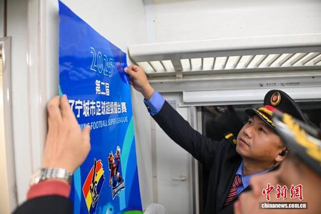 图为车上工作人员在车厢内布置赛事主题海报。中新社记者 于海洋 摄