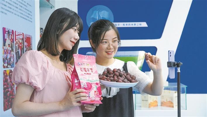 5月7日，阿拉尔市叁颗枣果品农民专业合作社理事长赵闫（右）进行网络直播，销售灰枣。朱志升 摄