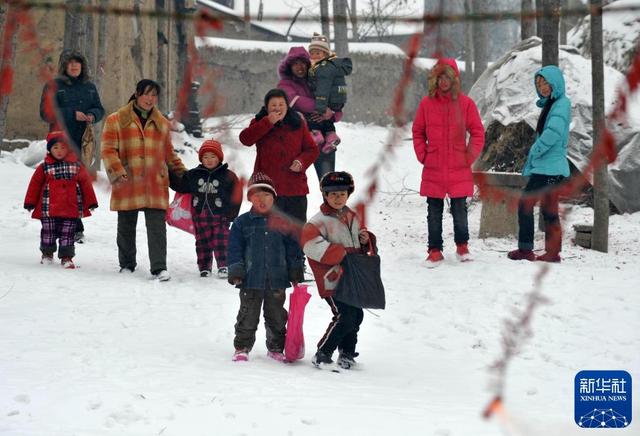 2010年2月14日，在河南新蔡县佛阁寺镇大展庄，村民在等待鞭炮燃放后到邻居家拜年。 资料图：新华社