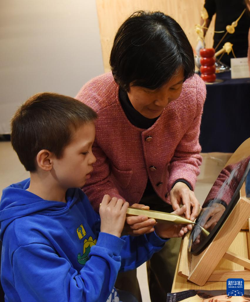 11月26日，在荷兰海牙中国文化中心，一名小朋友体验石影雕技艺。新华社记者 邵海军 摄