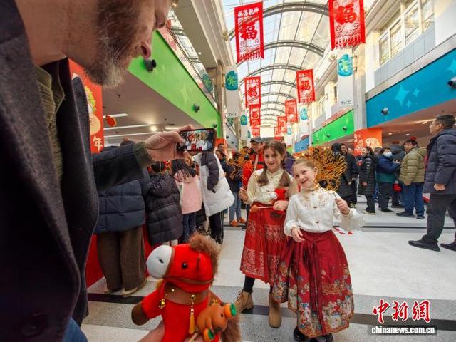 图为来自天津国际学校的外籍学生手持天津非物质文化遗产代表性项目糖画在现场合影。中新社记者 佟郁 摄