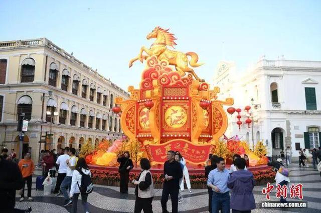 市民和游客在澳门议事亭前地广场，与骏马装饰合影留念。中新社记者 郑嘉伟 摄