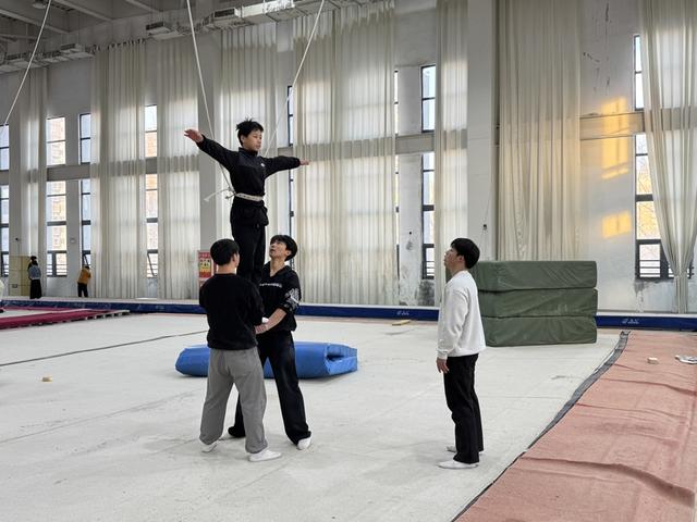 沛县体育中学体育馆内，学生们在教练的指导下练习技巧动作（金亦辰 摄）