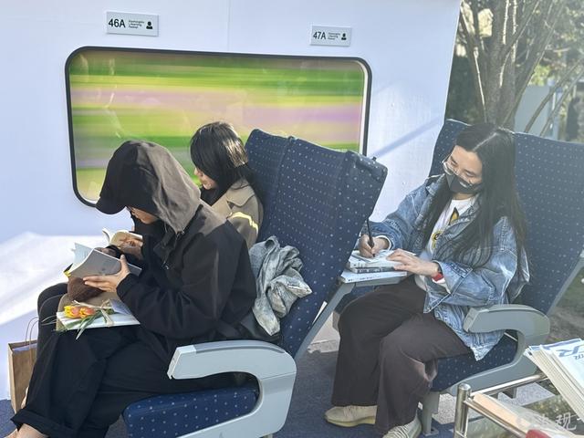 在布置成高铁车厢场景的地方写作。施晨露摄